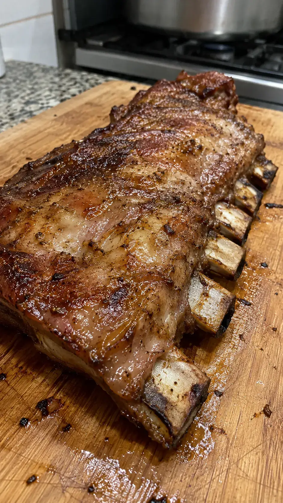 Costillar de cerdo dorado con sus huesos visibles sobre una tabla