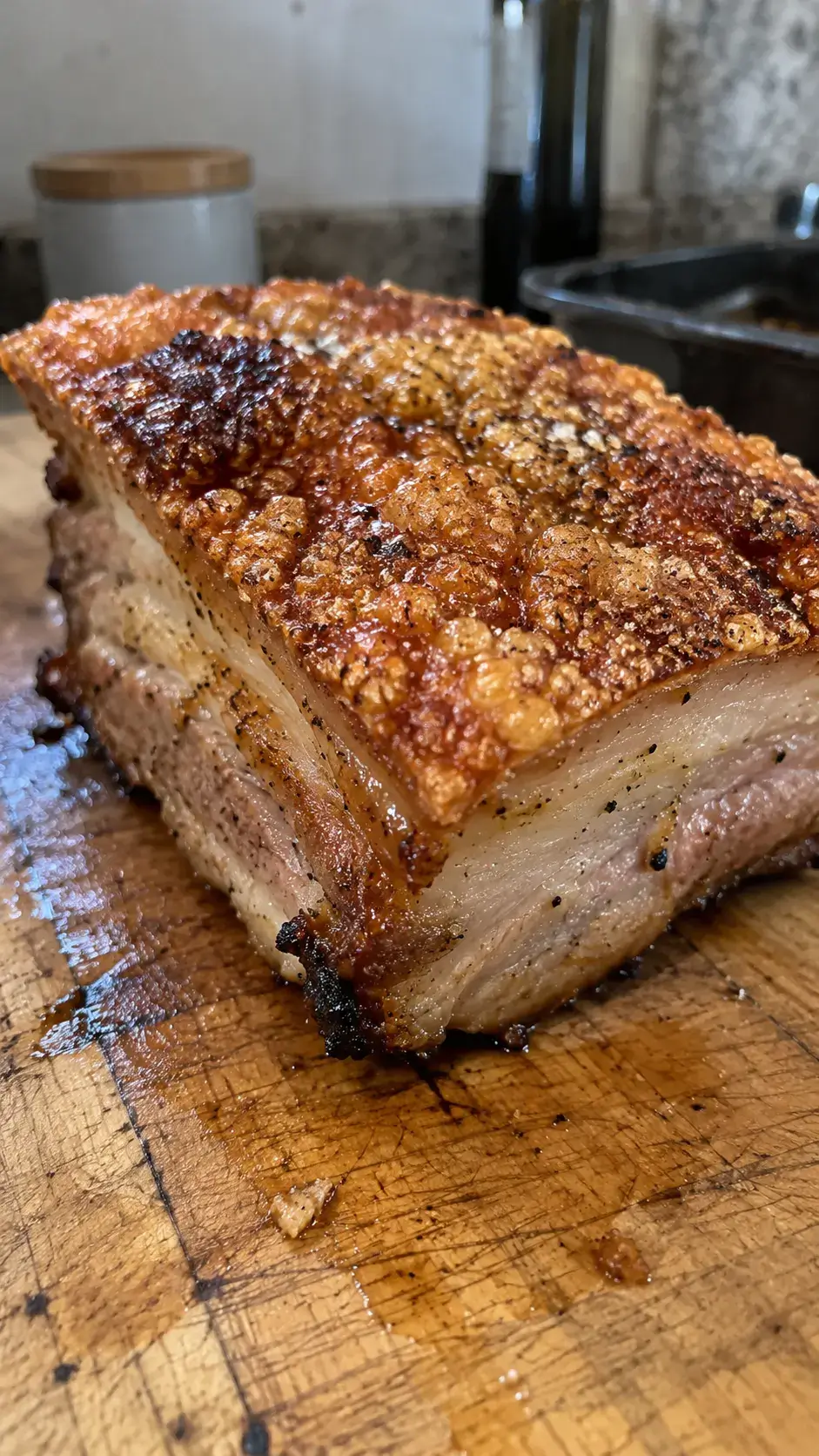 Panceta de cerdo con la piel dorada y crujiente sobre una tabla